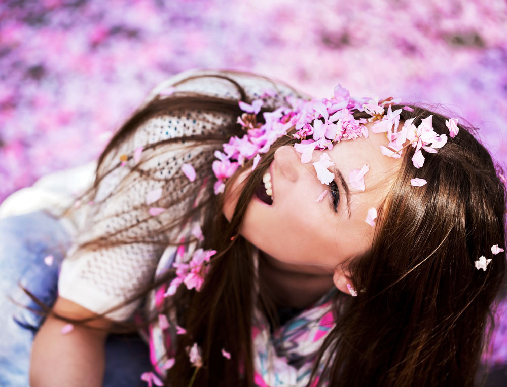 Girl, under a shower of petals.